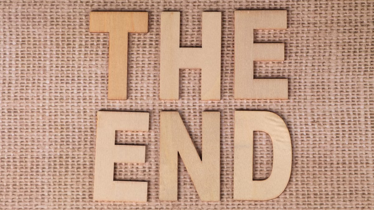 Wooden letters arranged to spell 'The End' on a burlap background.